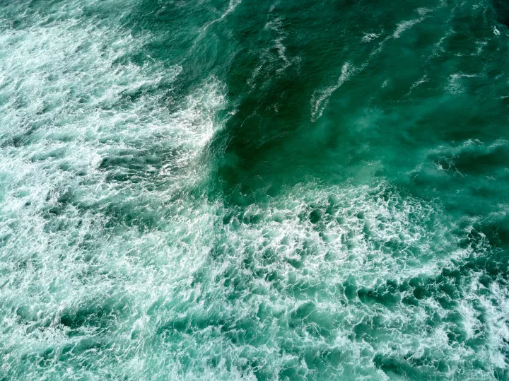 Churning teal ocean water seen from above